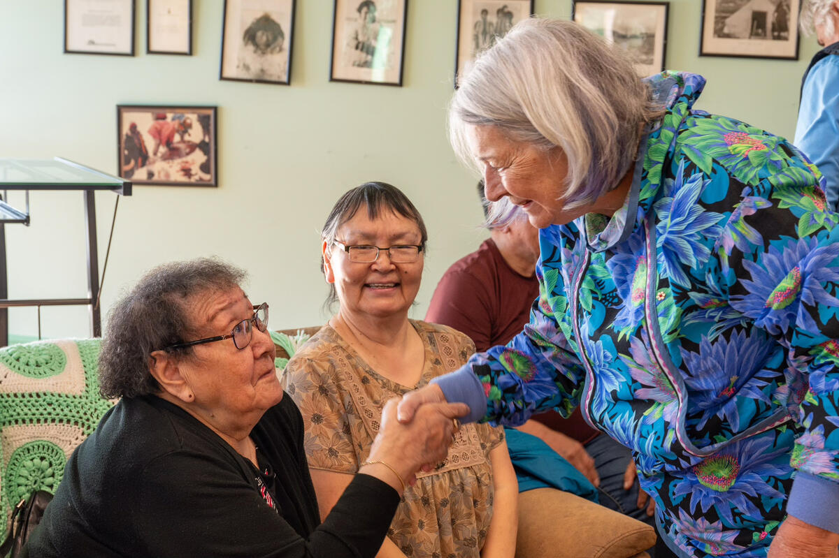 Governor General Mary Simon shakes hands with an elder during her visit to the Elders’ Qammaq