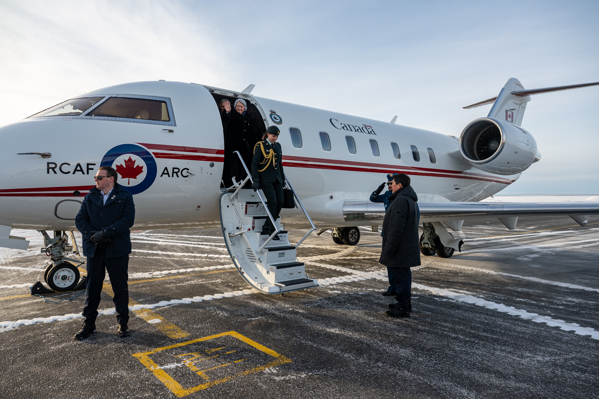 Governor General Mary Simon descending the steps of a plan upon arriving in Greenland.