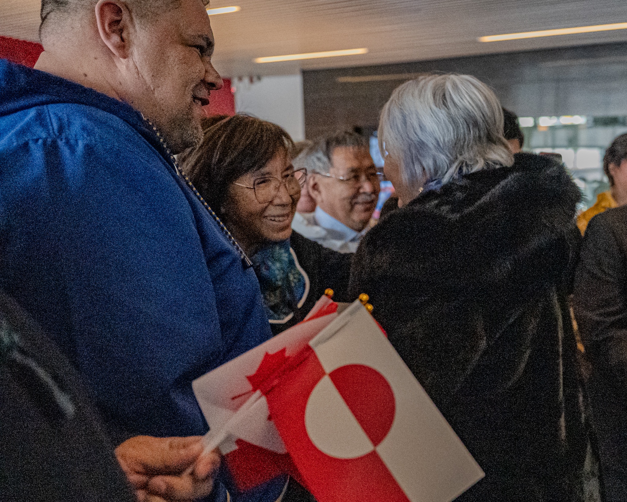 Governor General Mary Simon greeting someone in the crowd of people welcoming her in Greenland.