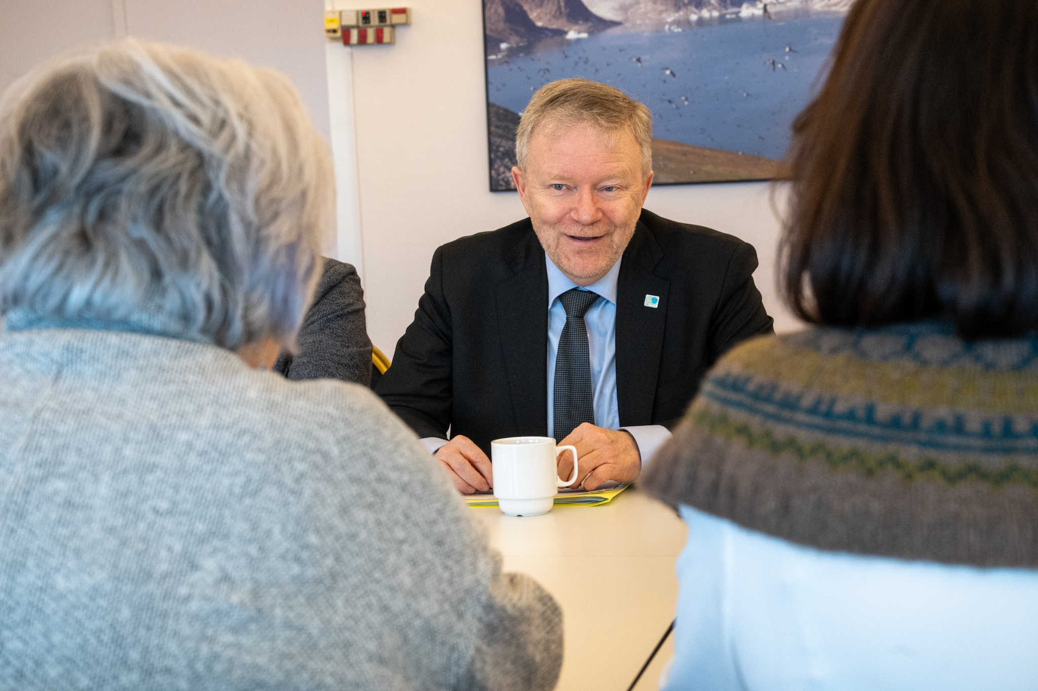 Kenneth Høegh, Chair of Senior Arctic Officials for the Arctic Council, is seated at a table across from the Governor General. He has a cup of coffee in front of him.