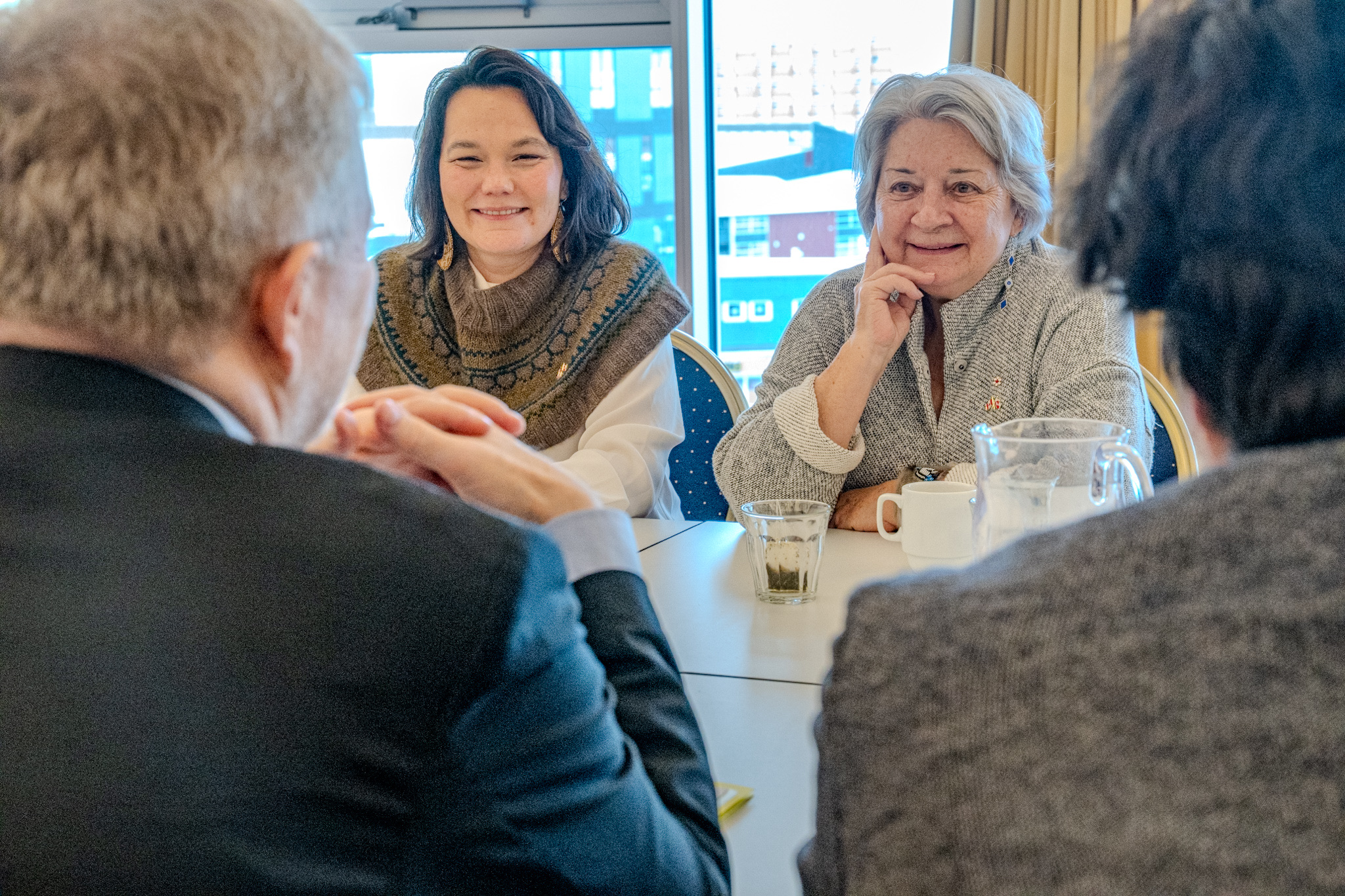 A group of people sitting around a table, engaged in conversation.