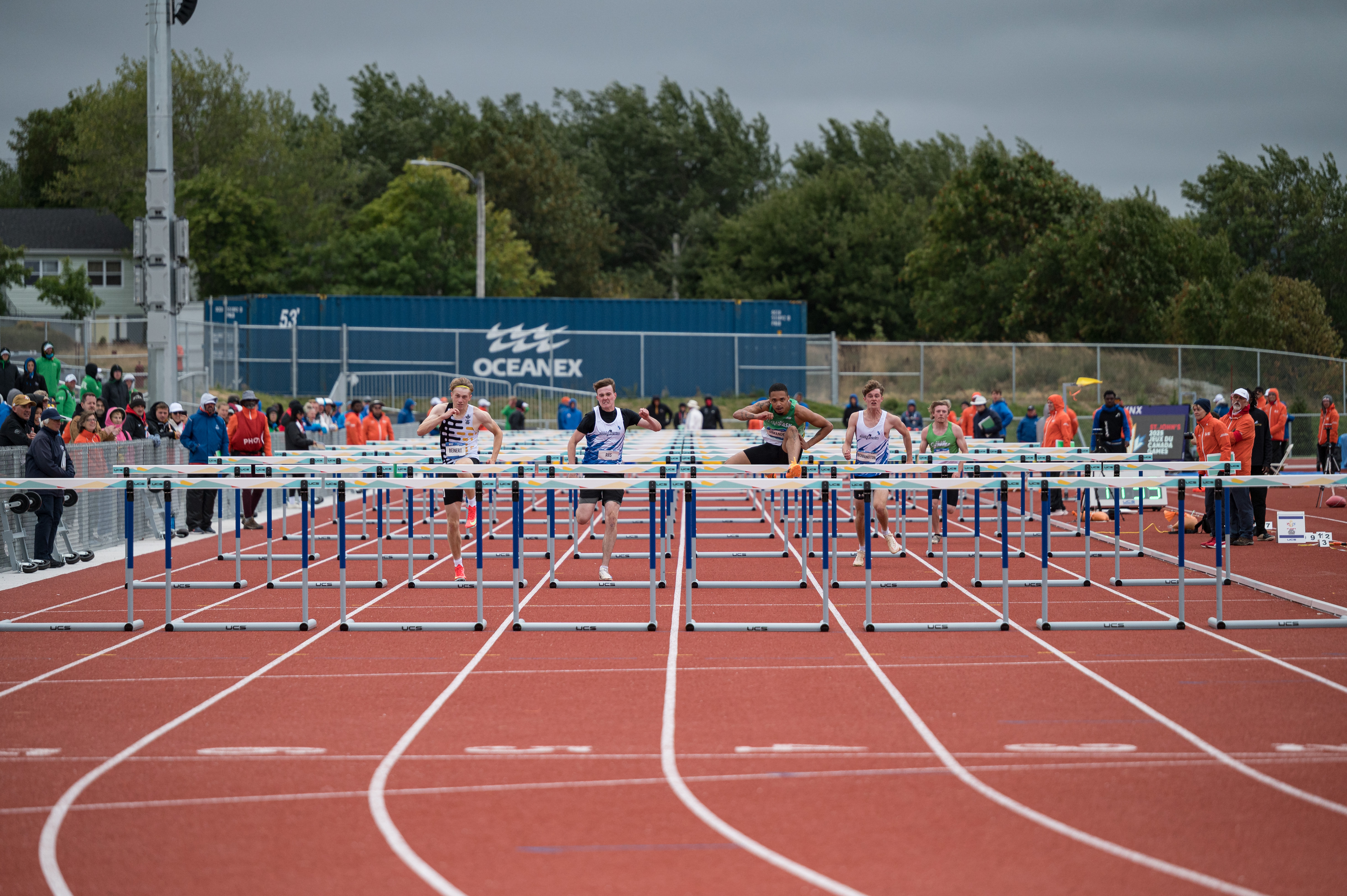A group of athletes competing in hurdles.