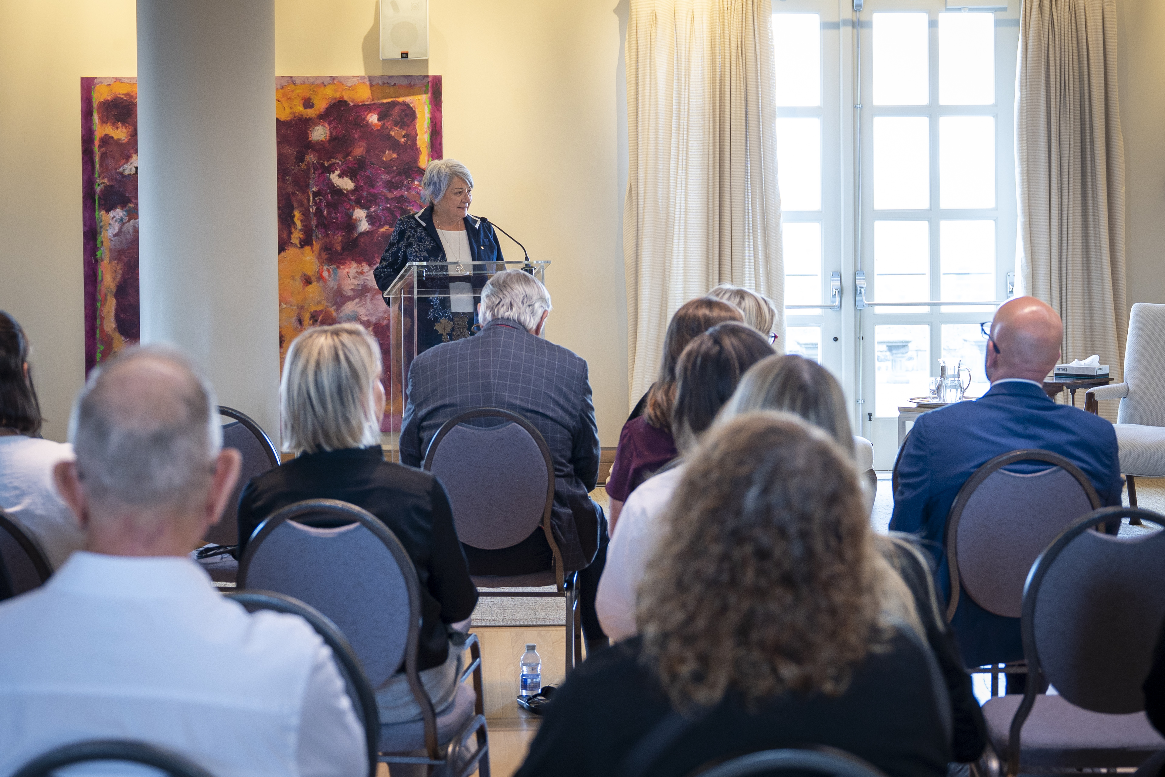 "Governor General Mary Simon is standing at a podium addressing a room of people.