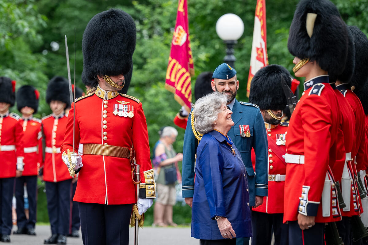 Governor General Arbour completing an inspection of the Ceremonial Guard. She is smiling up at one of the members.