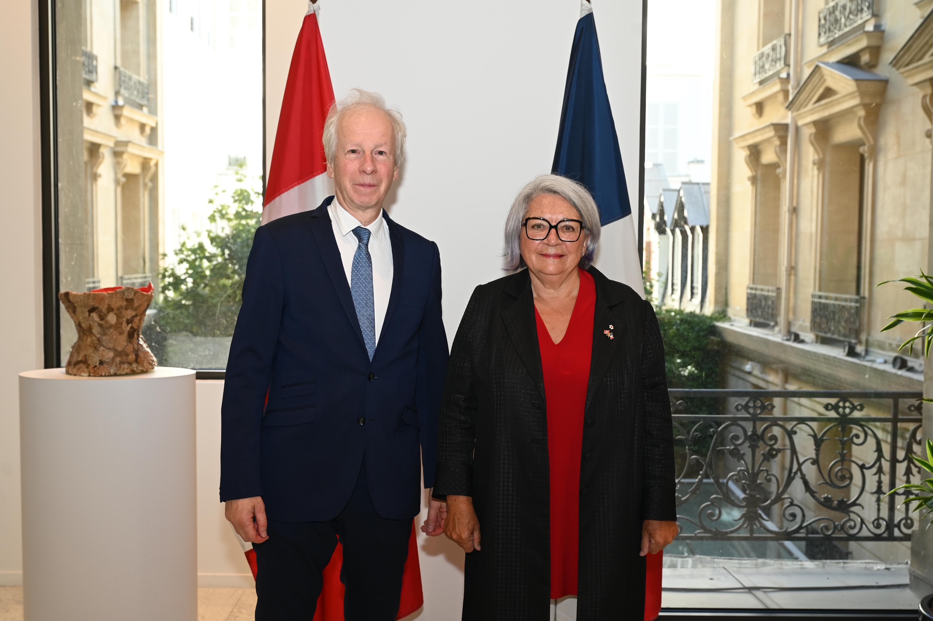 La gouverneure générale Mary Simon se tient à côté de l'Ambassadeur du Canada en France, Stéphane Dion. Ils ont un sourire.