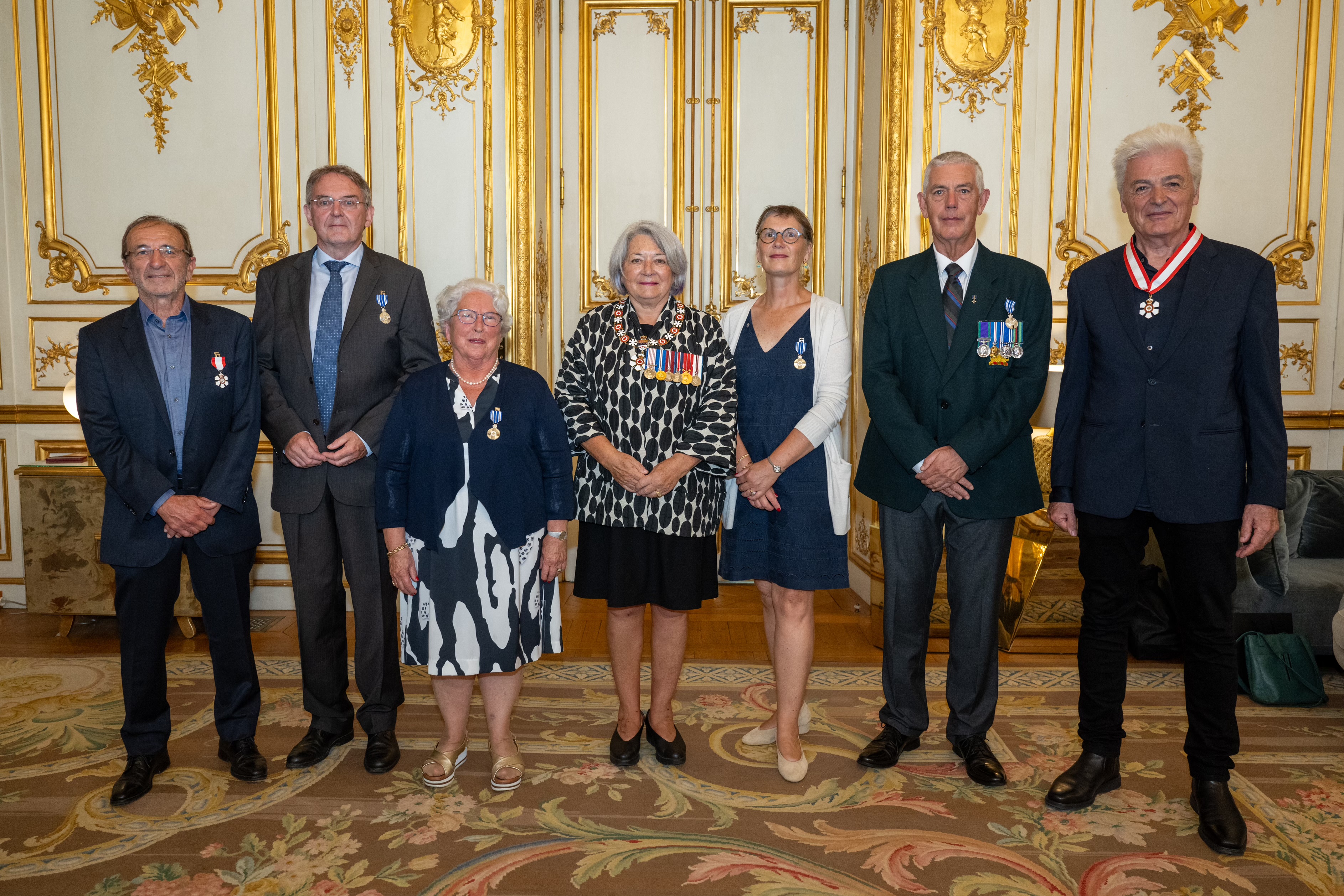 La gouverneure générale Mary Simon se tient avec un grand groupe de personnes. Le groupe pose pour une photo.