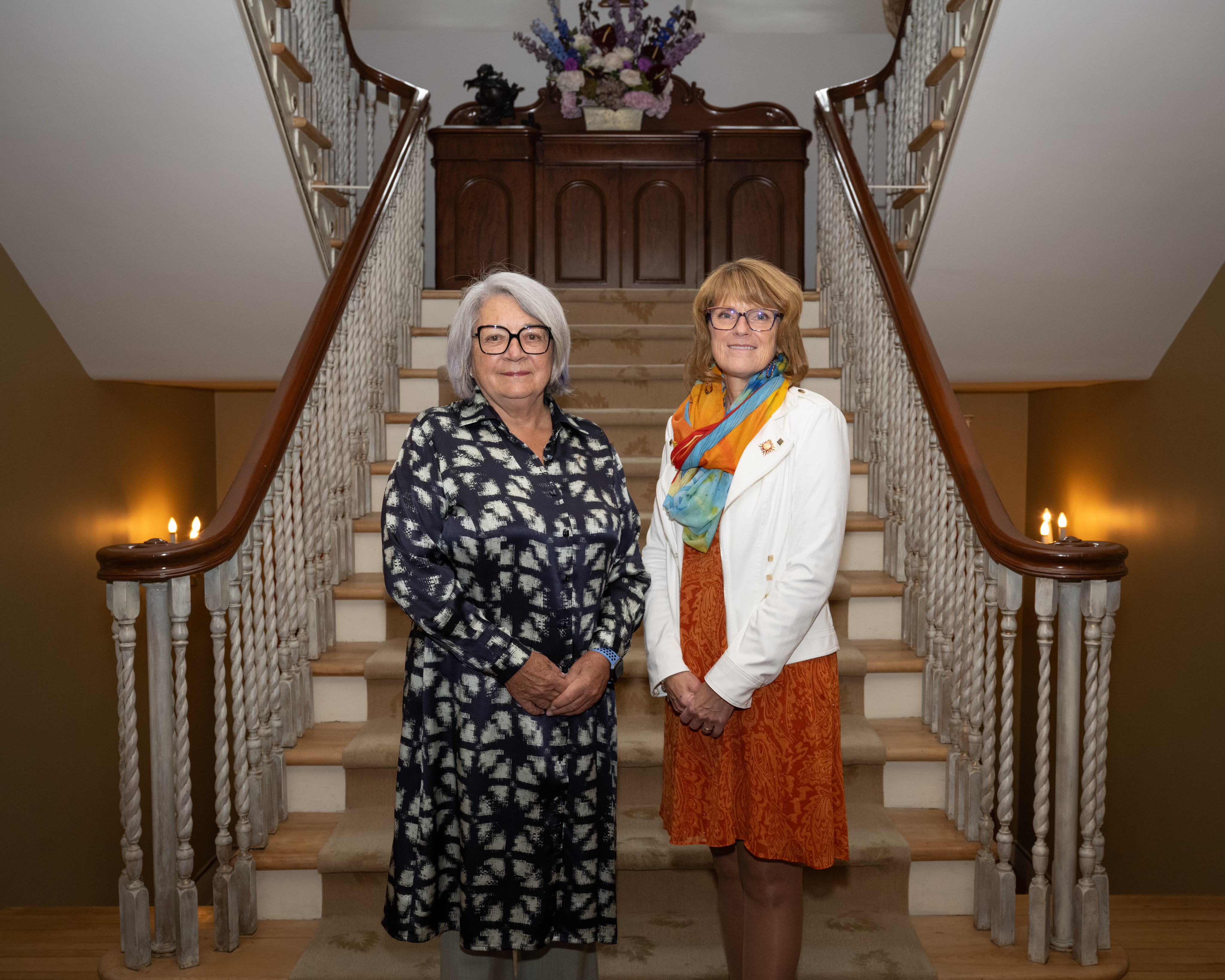 Governor General Simon standing next to the Honourable Manon Jeannotte, Lieutenant Governor of Quebec. They are standing in front of a staircase. 