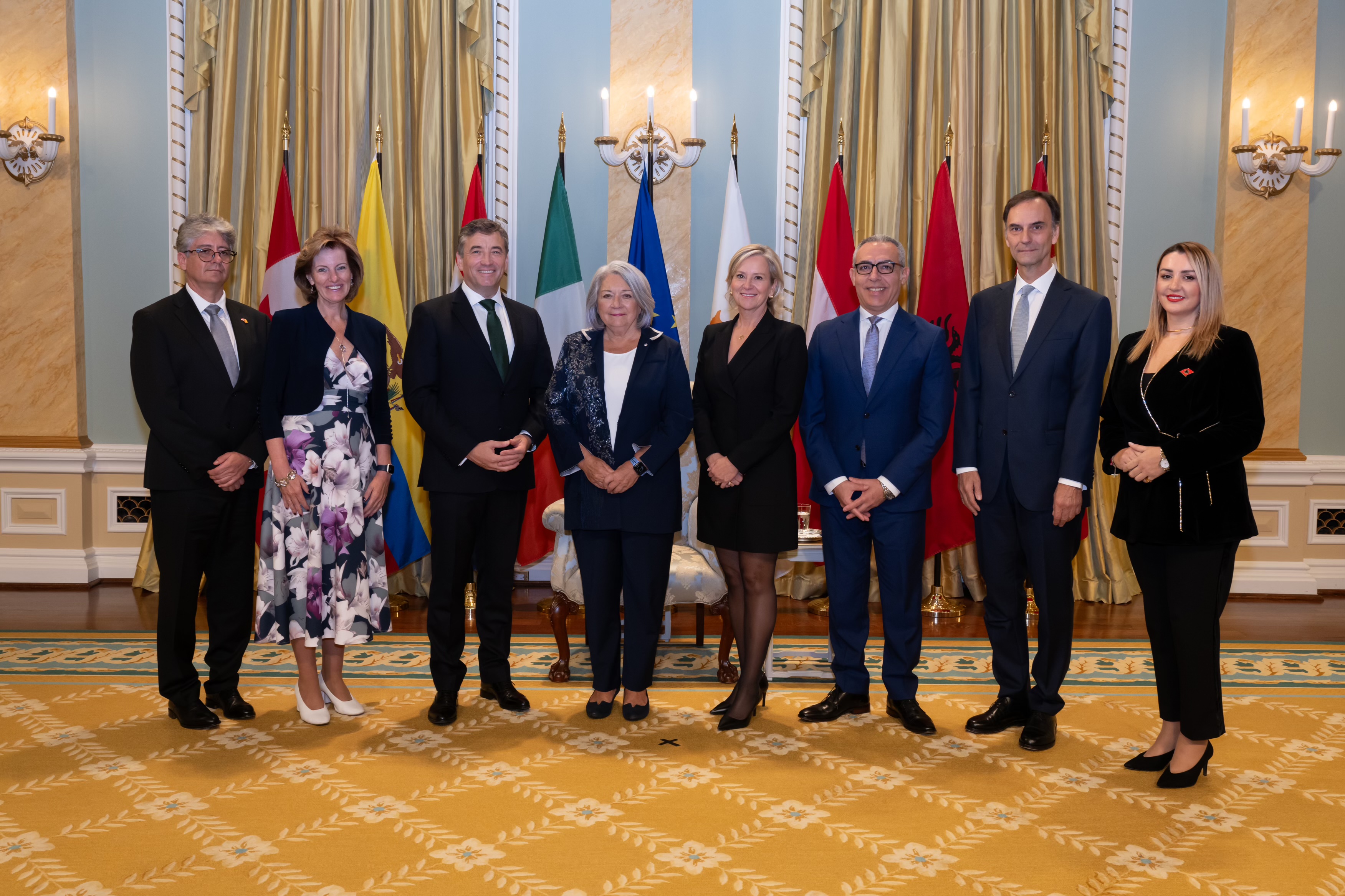 A group photo with Governor General Simon and seven new heads of mission, with the flags of each country behind them.
