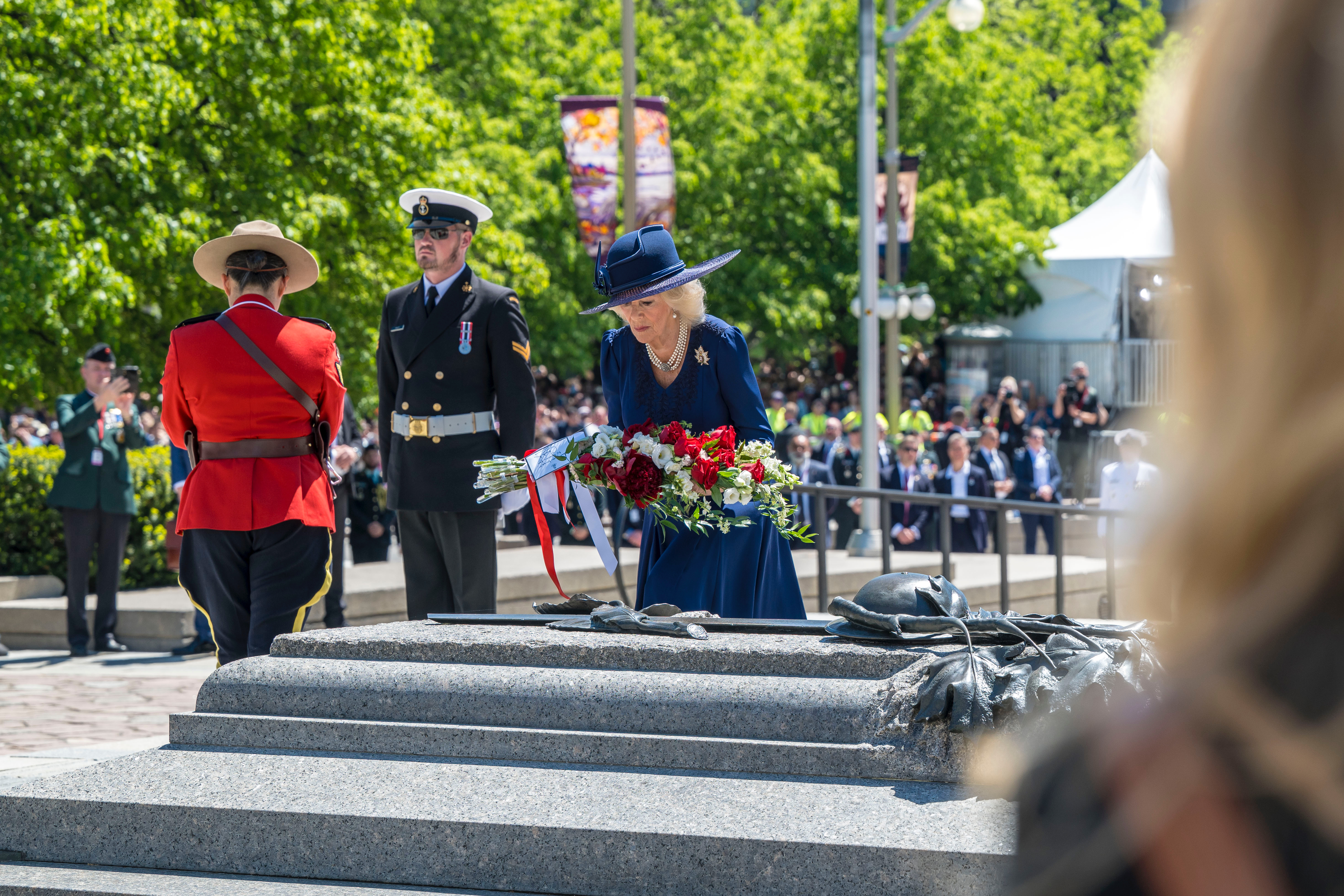 Queen Camilla placing a bouquet of flowers at the Tomb of the Unknown Soldier.
