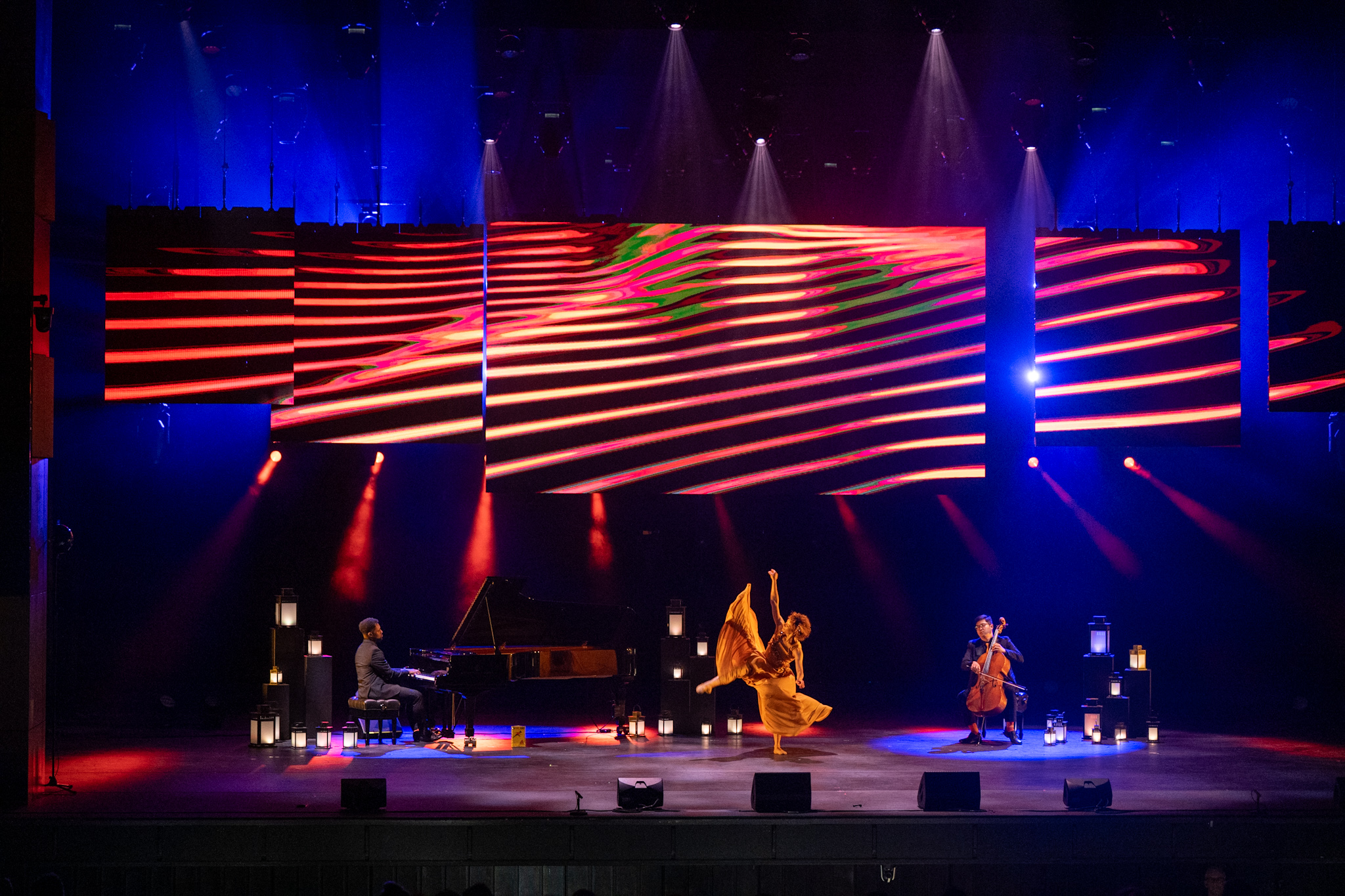 A pianist, cellist and dancer performing onstage at the National Art Centre as part of the Governor General Performing Arts Awards show. There are several lanterns on the stage.