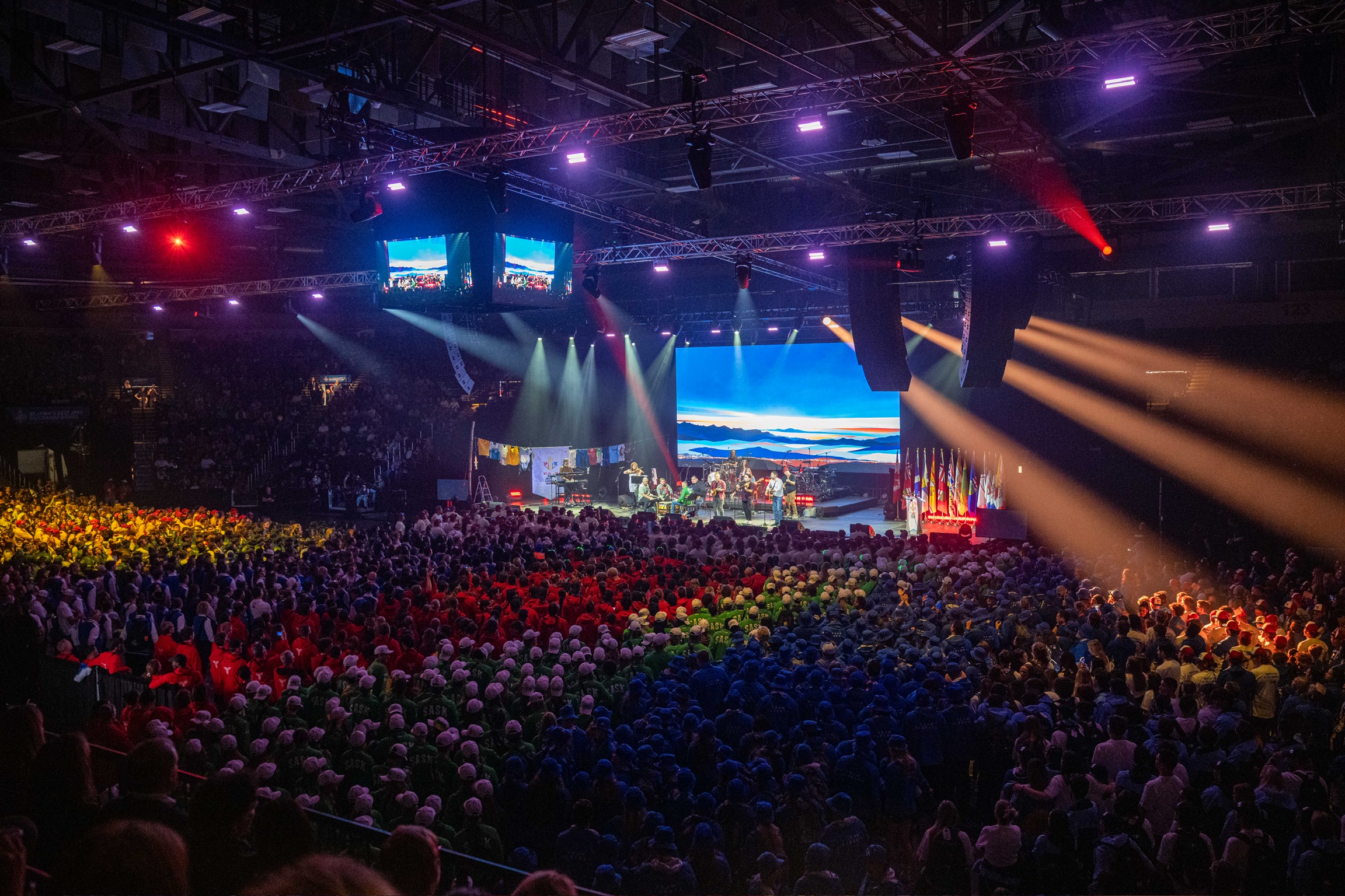 Stadium filled with people as a band plays on stage.