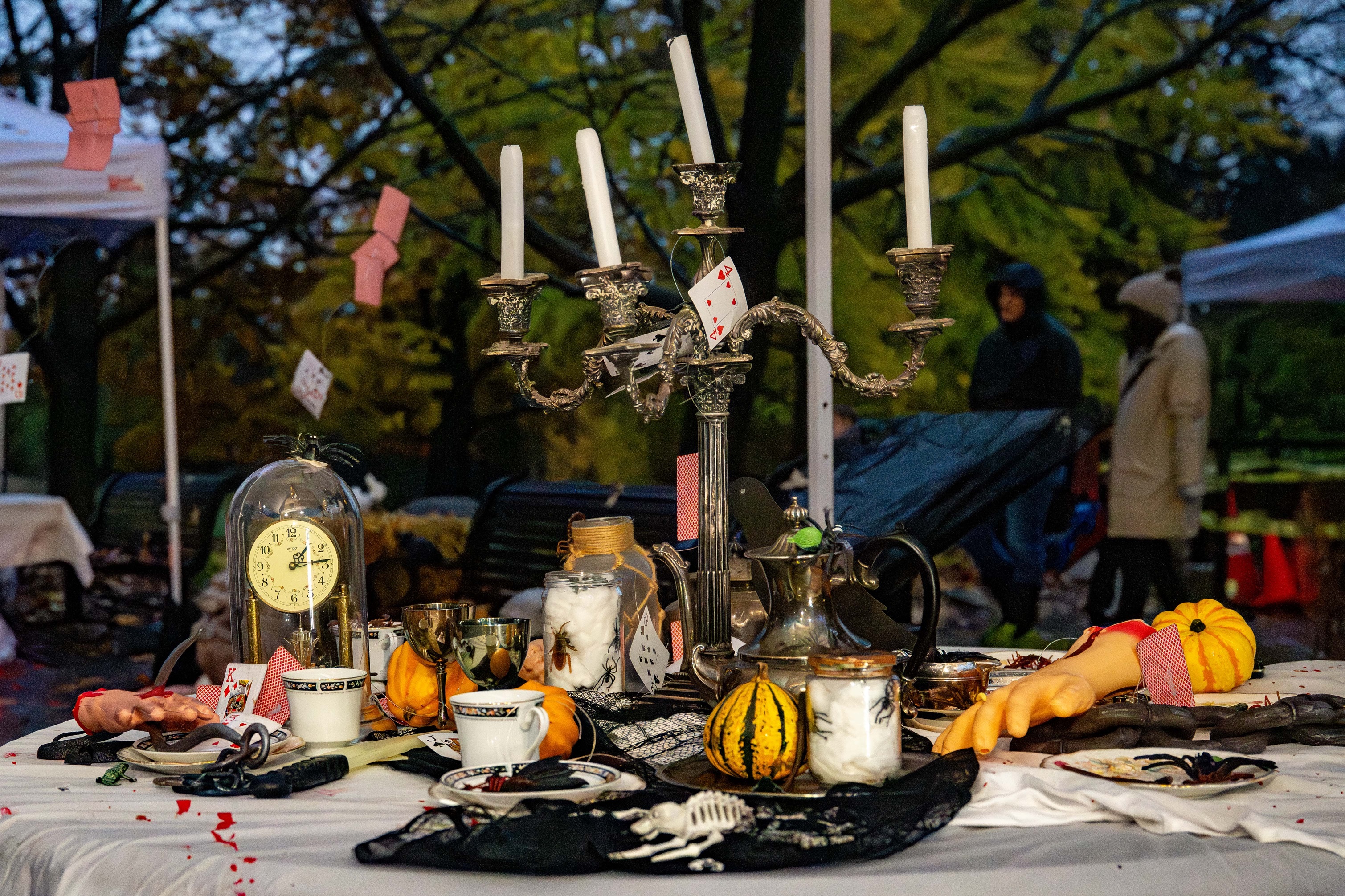 Halloween-theme tea party set up on a white table cloth with skeletons and spiders.