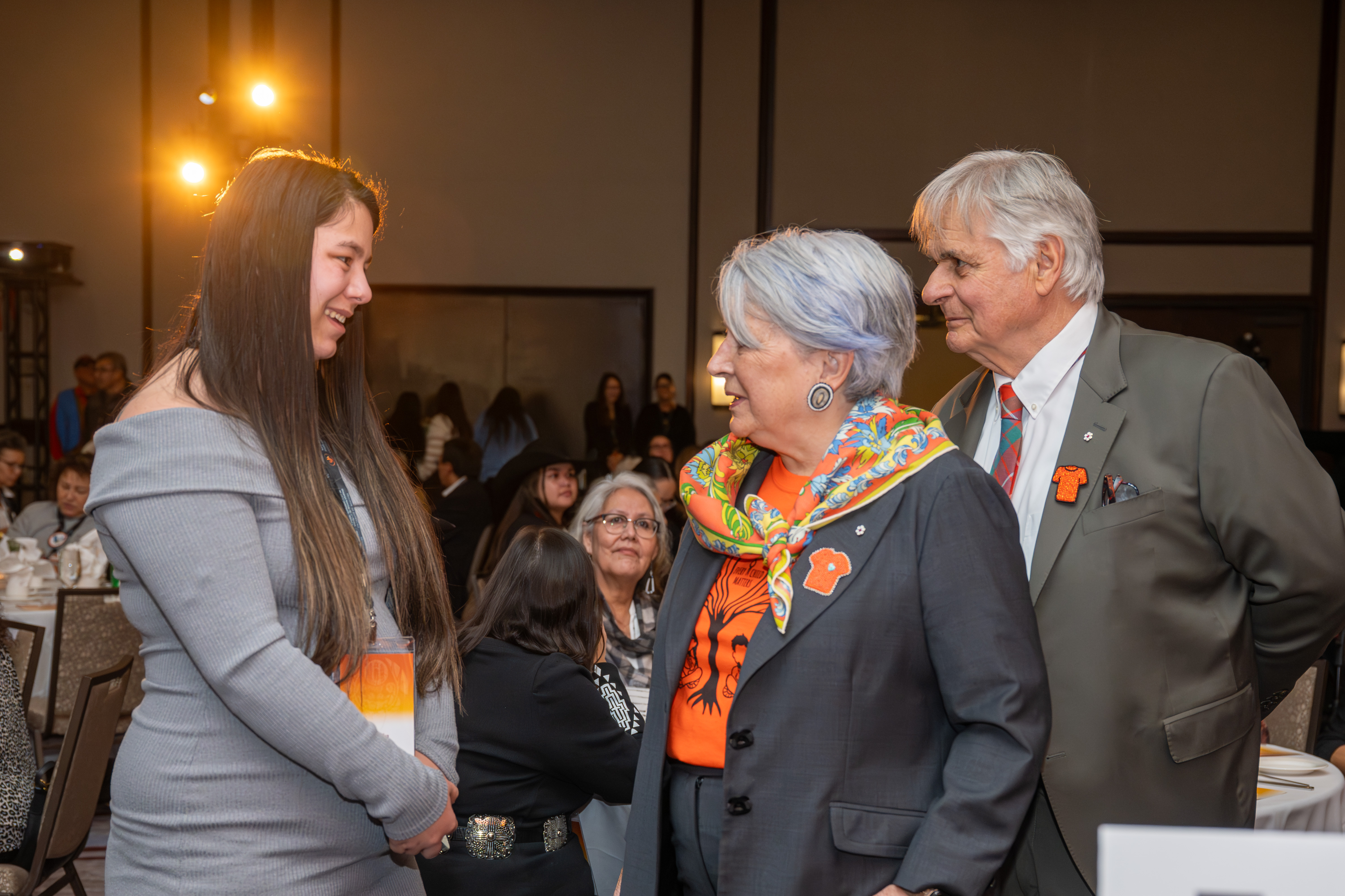 Governor General Mary Simon speaking to a woman in a large ballroom.