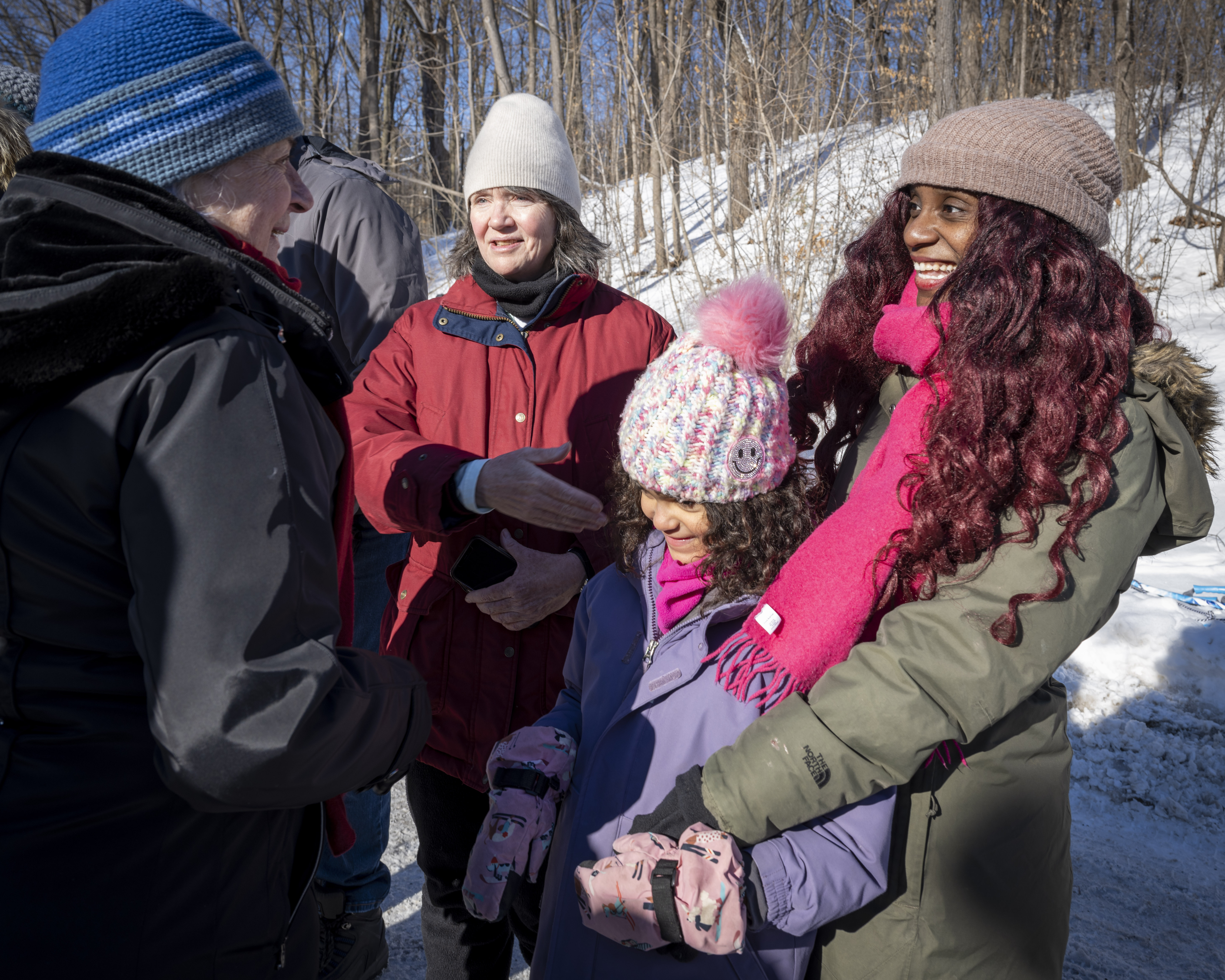 Governor General Mary Simon greeting a group of people including a young girl who is smiling, wearing a toque.