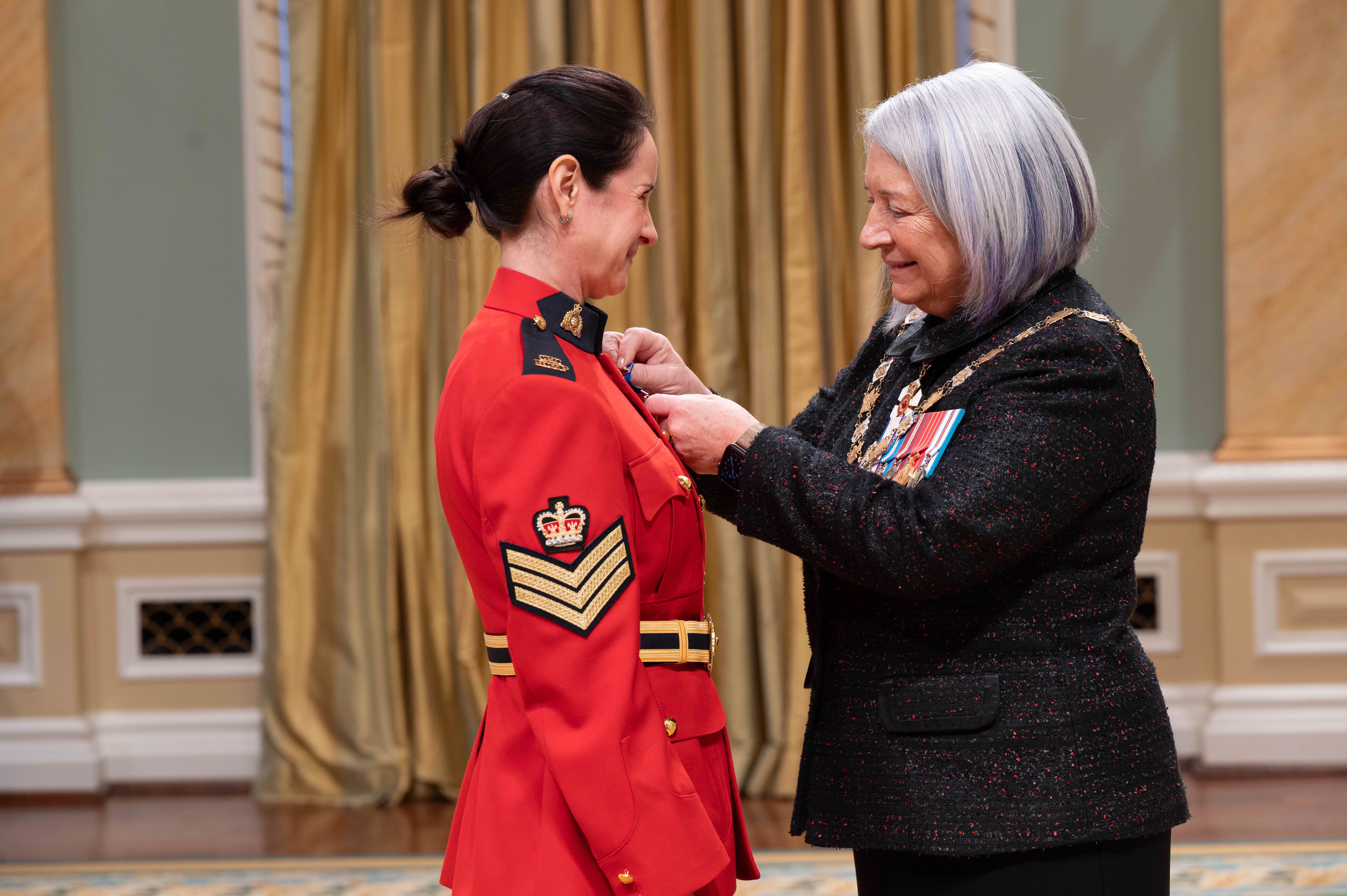 La gouverneure générale Mary Simon épingle une médaille à un membre de la Gendarmerie royale du Canada.