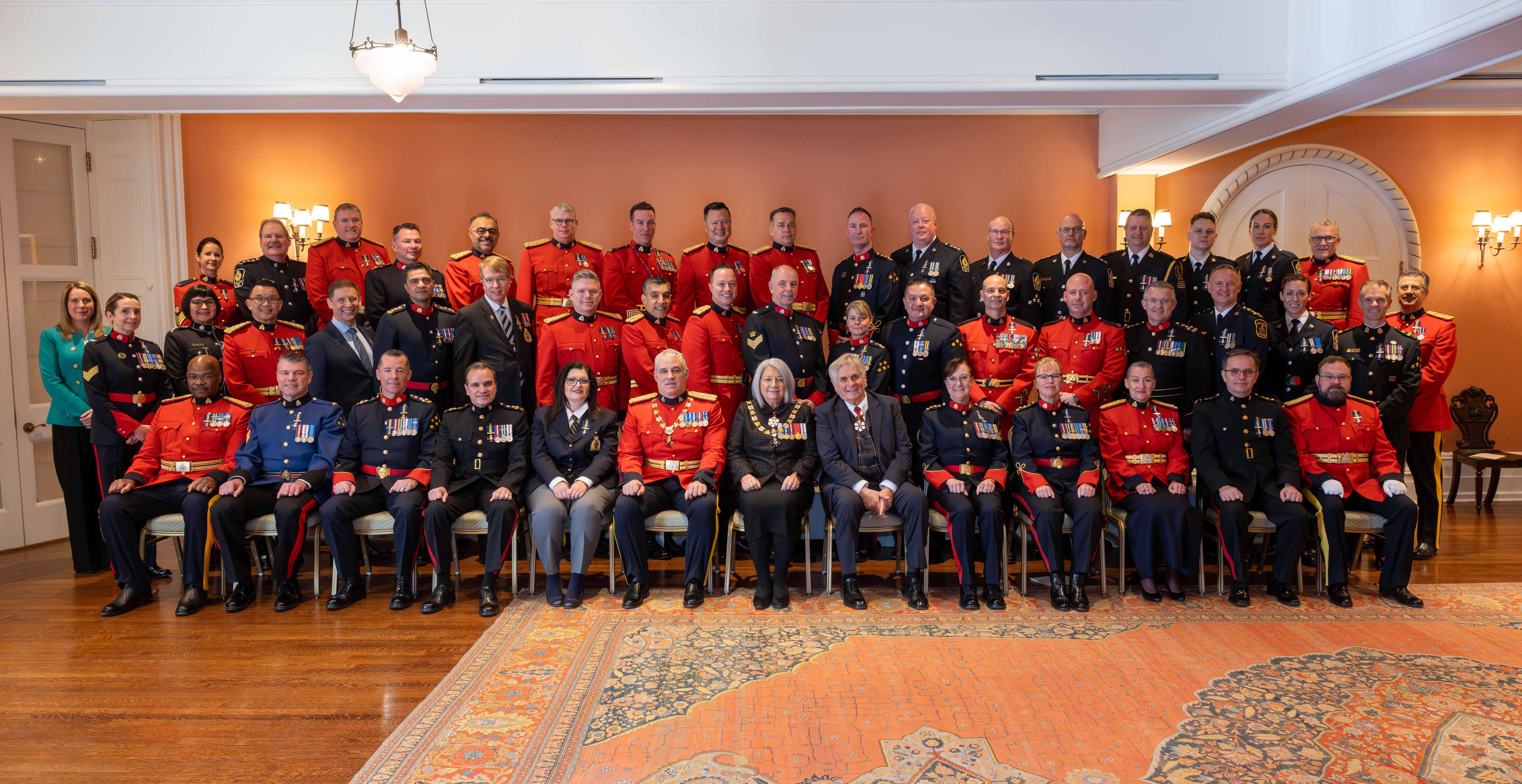 La gouverneure générale Mary Simon et M. Whit Fraser avec les récipiendaires de l'Ordre du mérite des corps policiers..