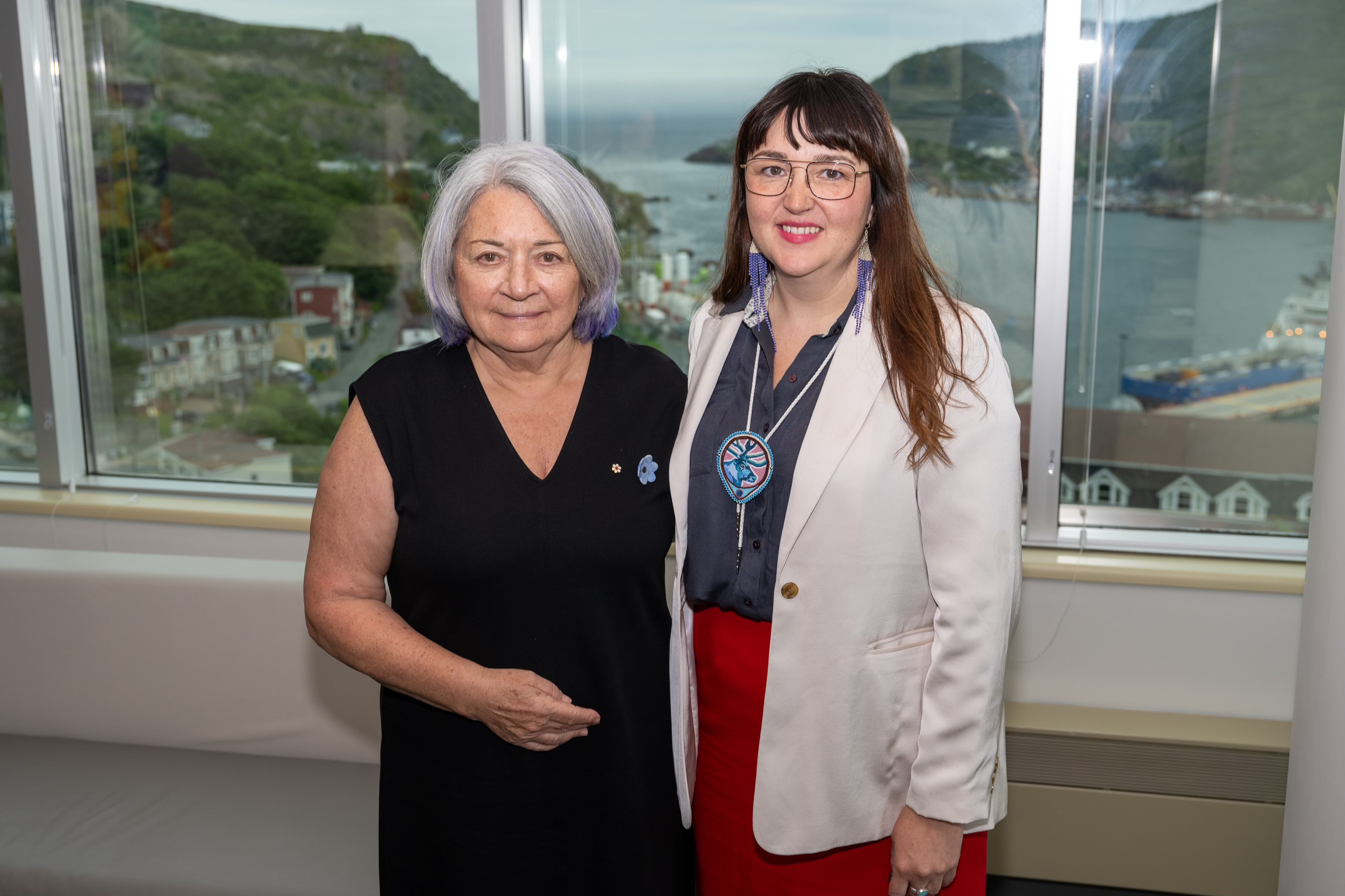 Governor General Simon standing next to Interim Chief, Western Vice-Chief, Jennifer Brake of Qalipu First Nation. There are large windows behind them.