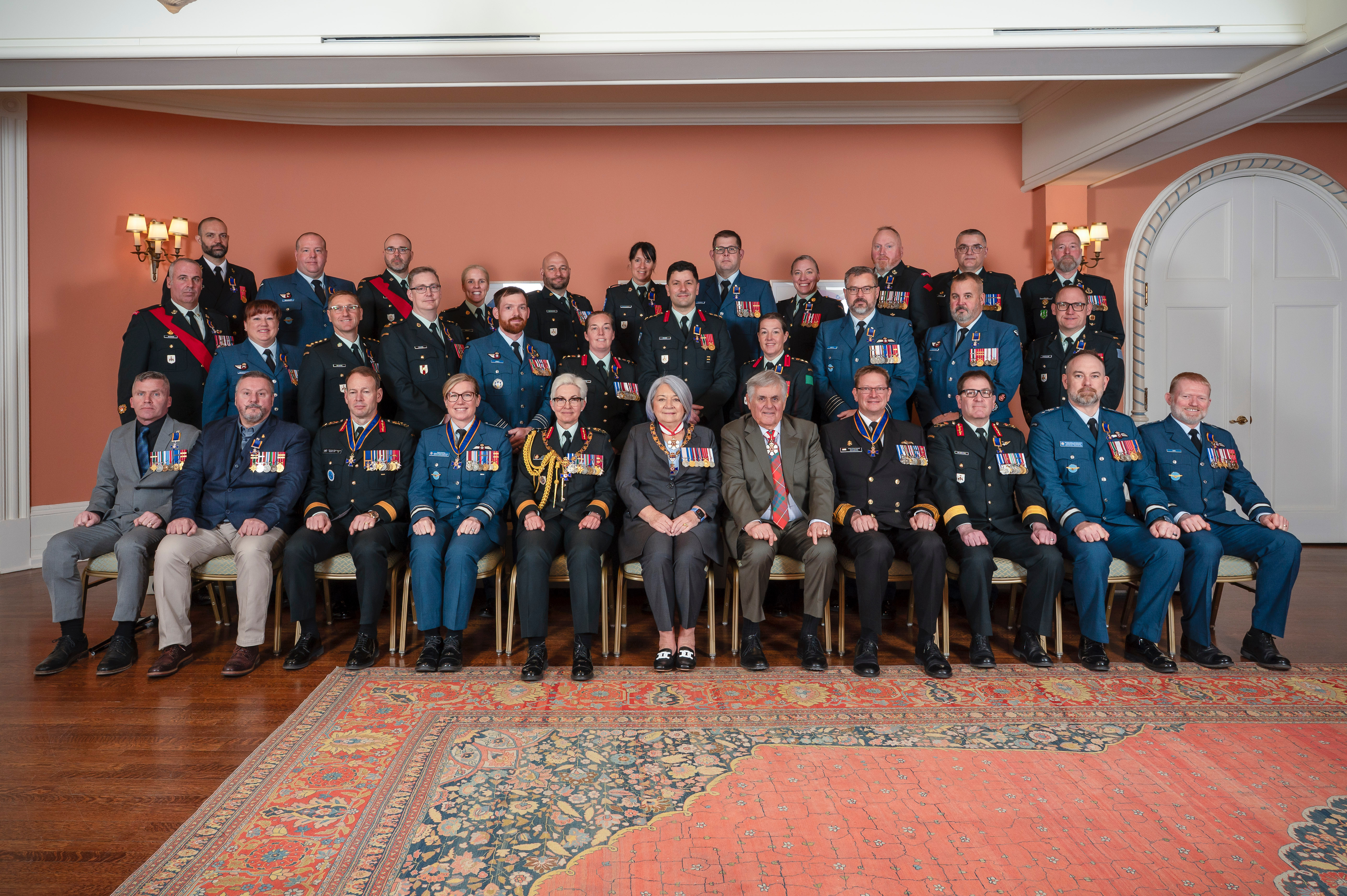 Governor General Mary Simon and Mr. White Fraser sitting in the center of a group photo featuring members of the Order of Military Merit.