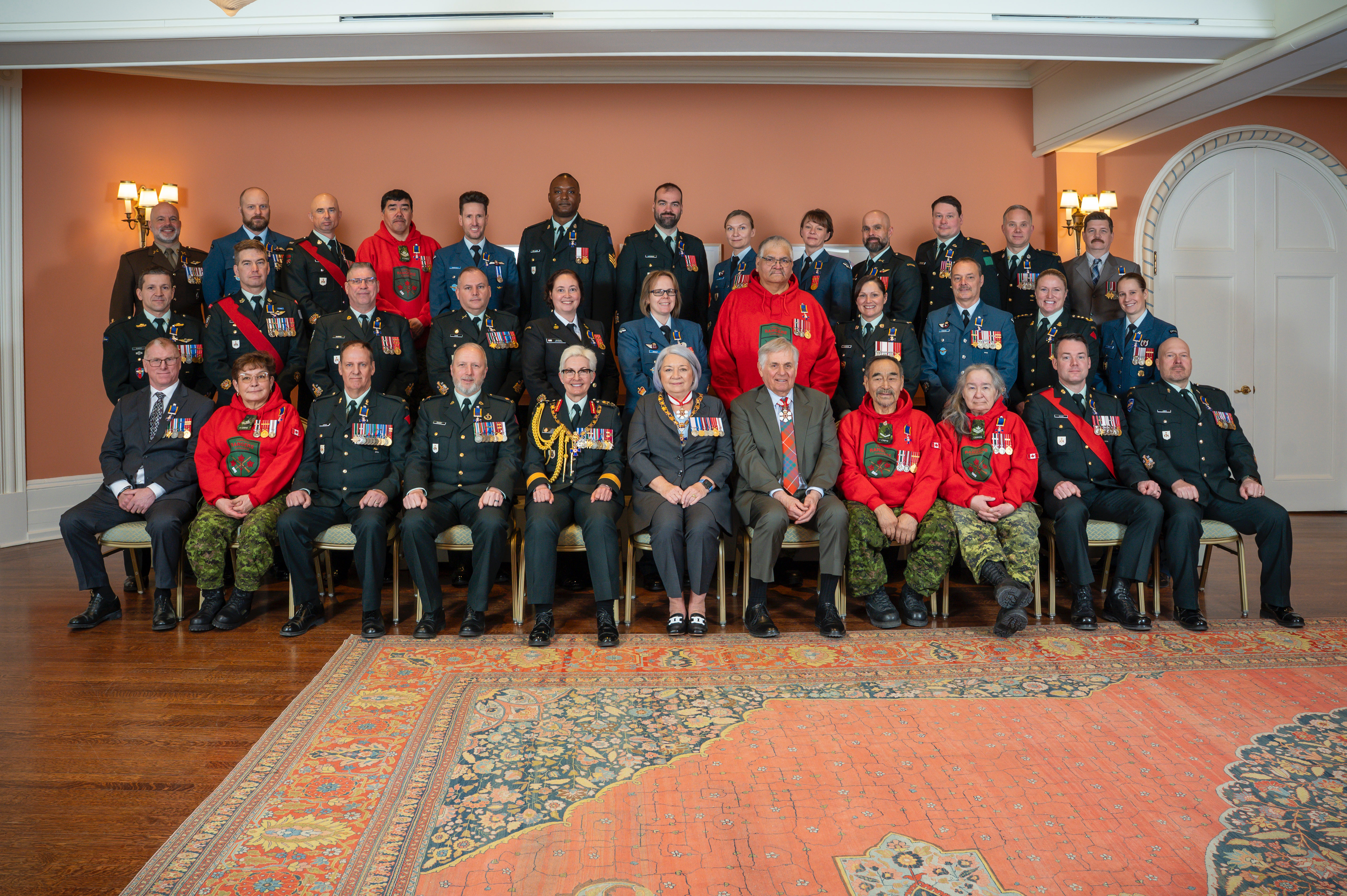 Governor General Mary Simon and Mr. White Fraser sitting in the center of a group photo featuring members of the Order of Military Merit.