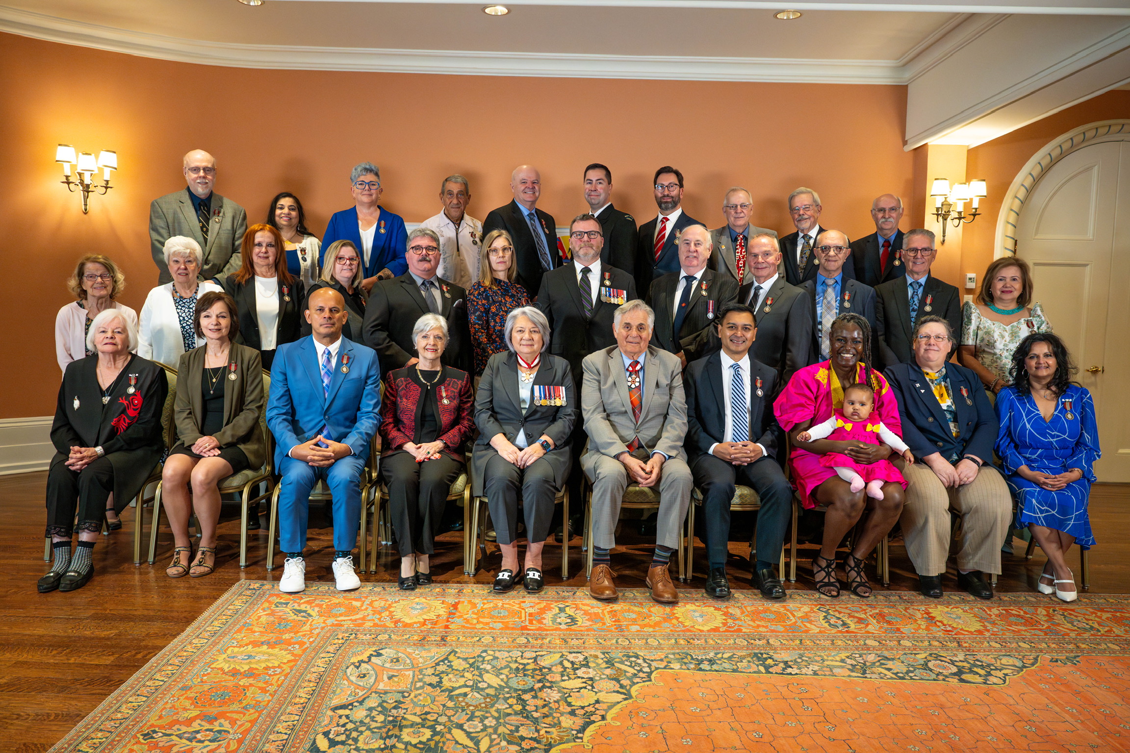Photo de groupe de la gouverneure générale Mary Simon et de M. Whit Fraser avec les récipiendaires de la Médaille du souverain pour les bénévoles..
