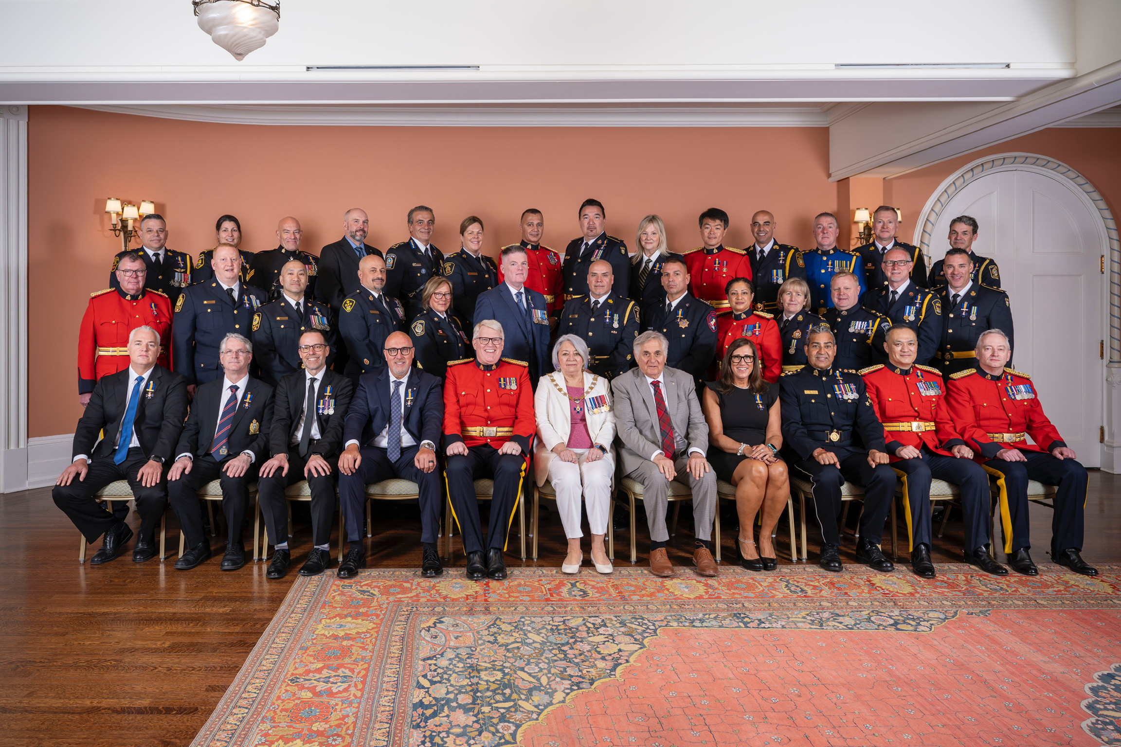 La gouverneure générale Mary Simon et M. Whit Fraser avec les récipiendaires de l'Ordre du mérite des forces de police.
