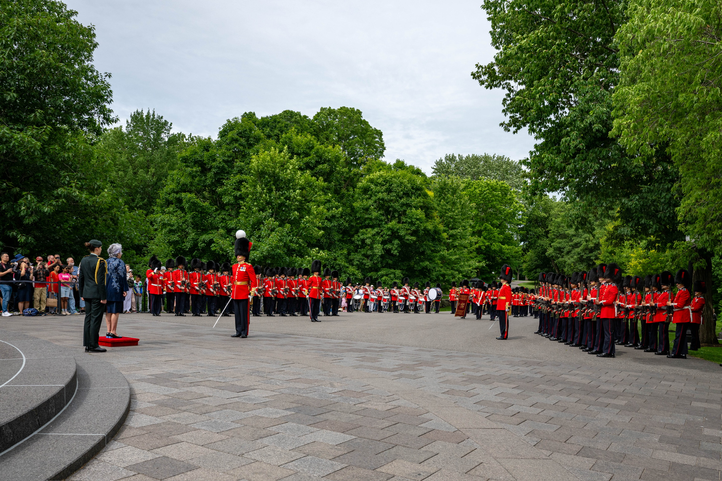 Governor General Mary Simon standing on a small platform the Ceremonial Guard.