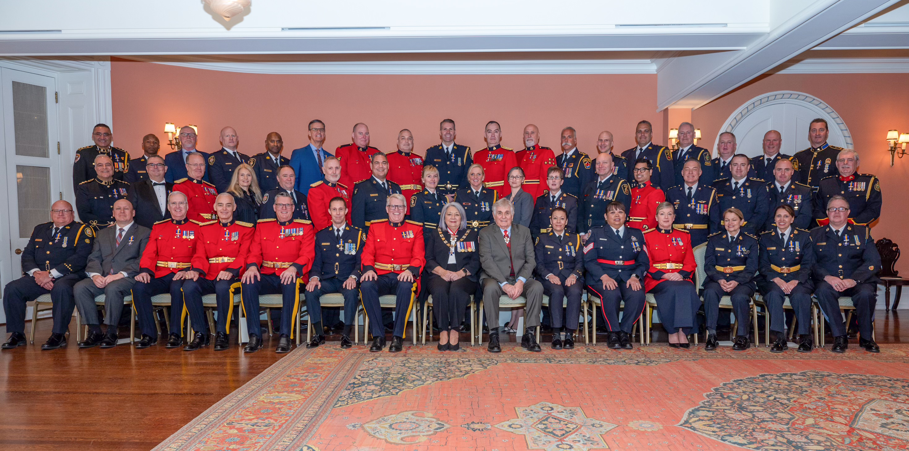 La gouverneure générale Mary Simon et M. Whit Fraser avec les récipiendaires de l'Ordre du mérite des corps policiers..
