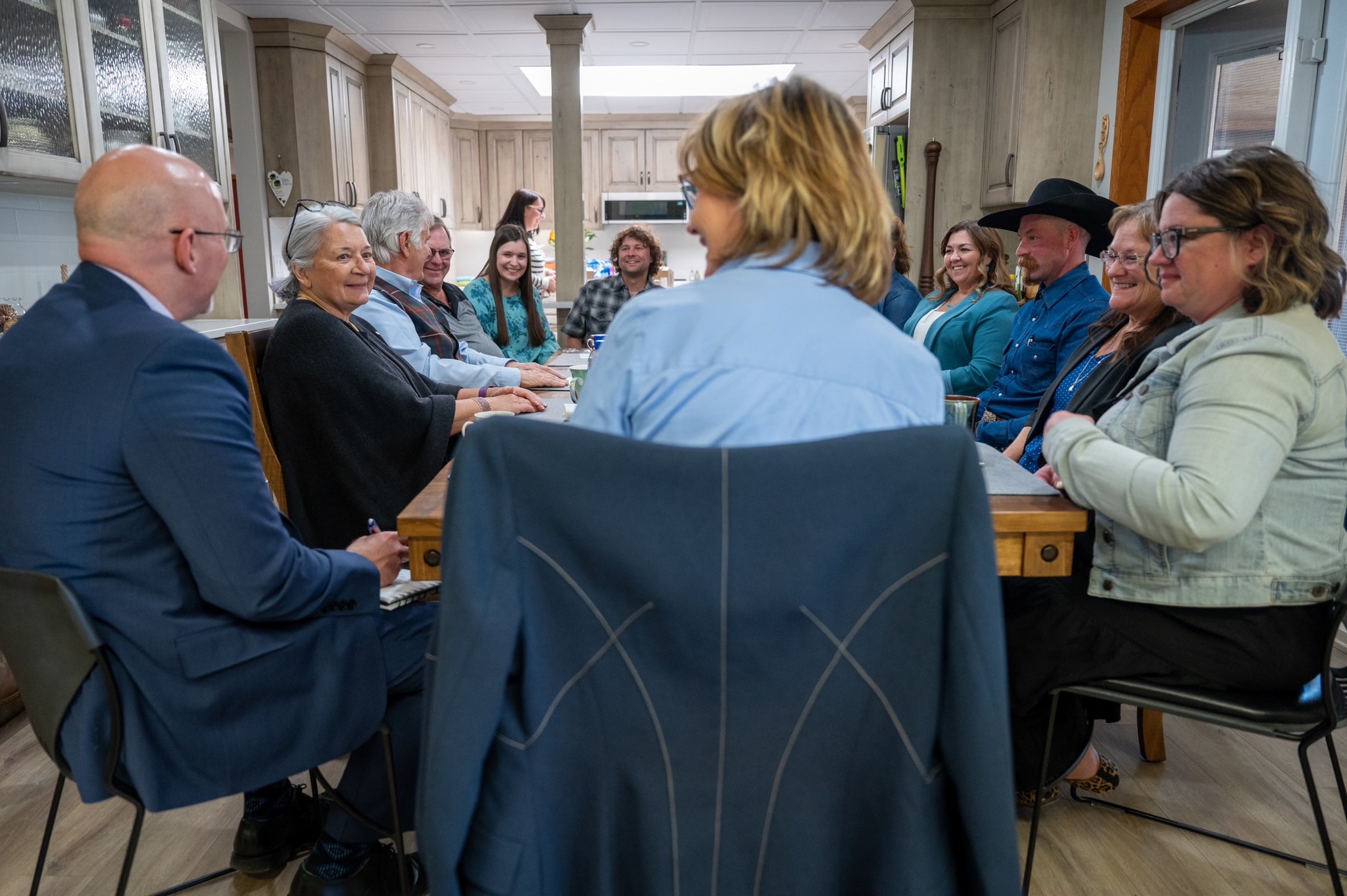 Plusieurs personnes, dont la gouverneure générale Simon, sont assises autour d'une grande table.