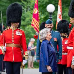 Governor General Arbour completing an inspection of the Ceremonial Guard. She is smiling up at one of the members.