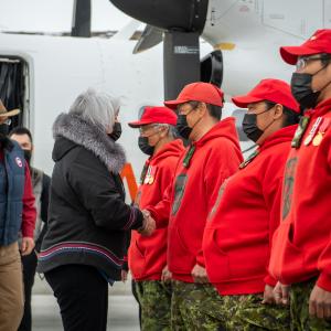 The Governor General is shaking hands with members of the Canadian Rangers guard.