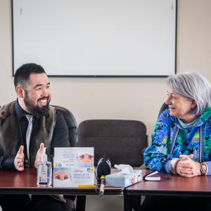The Governor General and the Mayor of Kangiqsualujjuaq are sitting at a table.