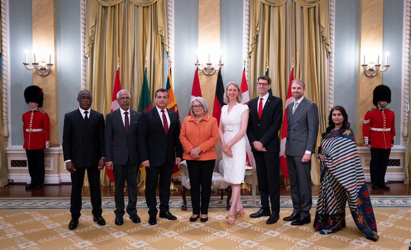 A group photo with Governor General Simon and seven new heads of mission, with the flags of each country behind them.