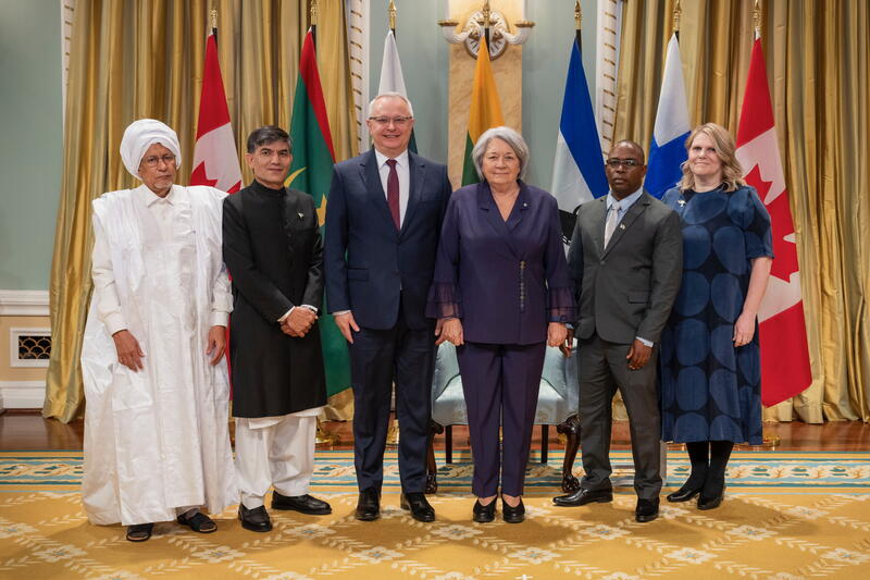 A group photo with Governor General Simon and five new heads of mission, with the flags of each country behind them.