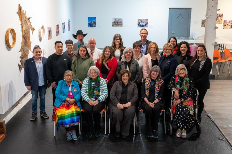 Photo de groupe de 21 personnes. La gouverneure générale Mary Simon est assise au premier rang avec quatre autres femmes. Le reste du groupe est derrière, hommes et femmes, en deux rangées.