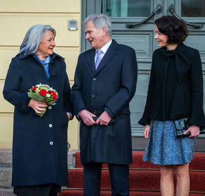 La gouverneure générale Mary Simon est debout à côté du président Sauli Niinistö et de son épouse, Mme Jenni Haukio. Son Excellence tient un bouquet de fleurs.