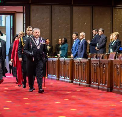 La gouverneure générale, précédée par l'huissier du bâton noir, entre dans la salle du Sénat. 