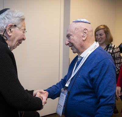 Deux survivants de l'Holocauste se serrent la main. 