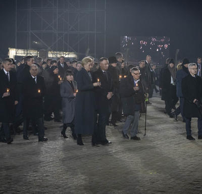 Des survivants et des leaders mondiaux marchent avec des bougies à la main. 