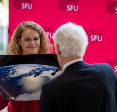 La gouverneure générale remet au président de l'Université Simon Fraser une photo de Vancouver prise depuis l'espace.