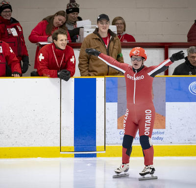 A speed skater raises his arms and readies to compete in the Special Olympics.