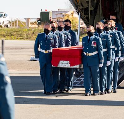 Le cercueil de la capitaine Jennifer Casey est transporté hors de l'avion par des membres des Forces armées canadiennes.