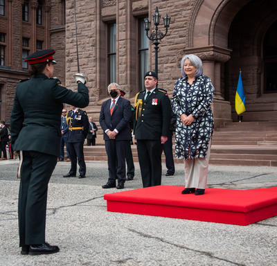 Le gouverneur général Simon se tient sur un podium rouge à l’extérieur de Queen’s Park.