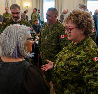 Governor General Simon is speaking with a member of the Canadian Armed Forces.