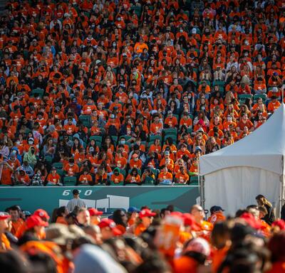 A crowd of people wearing orange shirts at a stadium.
