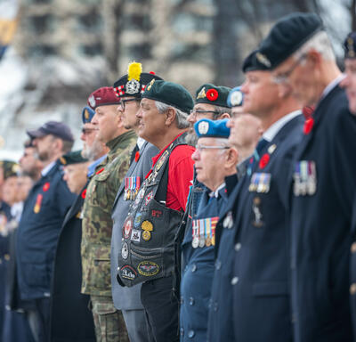 A row of people in uniforms are standing outside of the National War Memorial.