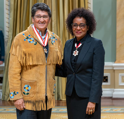 Former National Chief Ovide William Mercredi is standing next to The Right Honourable Michaëlle Jean.