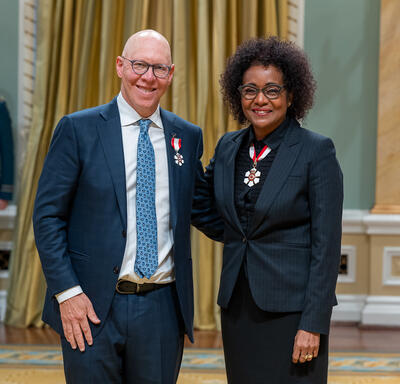 Aubrey Dan is standing next to The Right Honourable Michaëlle Jean.