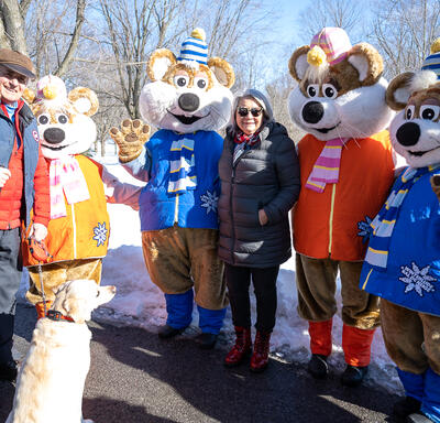 Governor General Simon and Mr. Whit Fraser stand next to the Winterlude Ice Hogs.