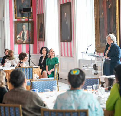 A group of women engage in conversation with Governor General Simon, in the Tent Room at Rideau Hall. 