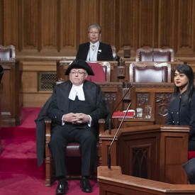 La gouverneure générale est assise dans la Chambre du Sénat et l'huissier du bâton noir reconnaît sa présence. 